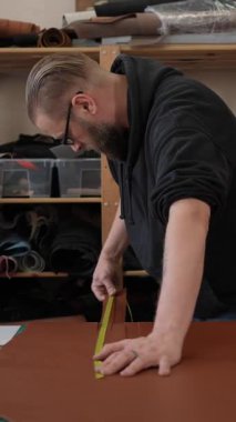 Beyaz sakallı adam bir atölyede bronzlaştırıcı olarak çalışıyor.