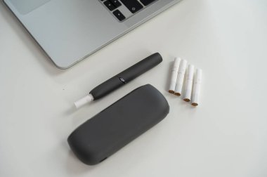 Bir dizüstü bilgisayarın yanında tütün ısıtma sistemi