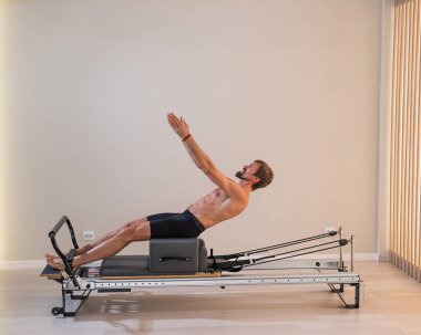 Reformcu üzerinde pilates yapan bir adam.