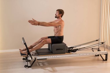 Reformcu üzerinde pilates yapan bir adam.