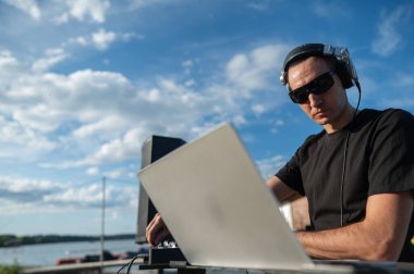 Beyaz adam plajda DJ olarak çalışıyor.