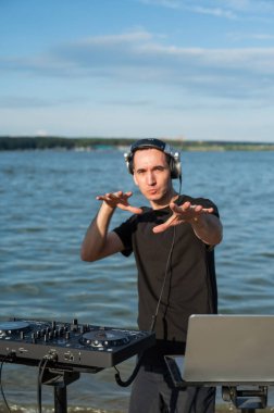 Beyaz adam plajda DJ olarak çalışıyor.