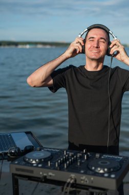 Beyaz adam plajda DJ olarak çalışıyor.