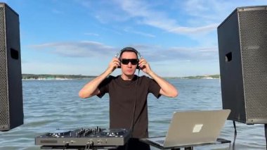 Beyaz adam plajda DJ olarak çalışıyor.