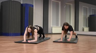 İki beyaz kadın dinamik bir kalas yapıyor.