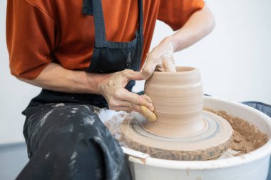 Çömlekçi elleriyle çömlekçi çarkında seramik vazo yaparken.