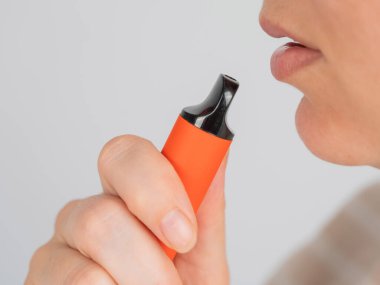 Beyaz kadın tek kullanımlık tüttürüyor.