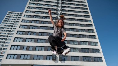 Kız trambolinde kayak numarası yapıyor.