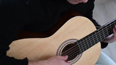 Genç adam akustik gitar çalıyor. Parmak Biçimi