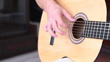 Genç adam akustik gitar çalıyor. Parmak Biçimi