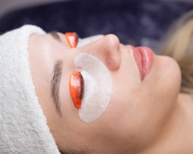 Beyaz kadın kirpik temizleme prosedüründen geçiyor.