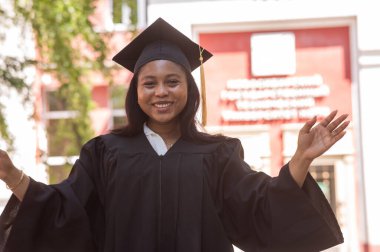 Mezuniyet elbisesi içinde mutlu bir Afrikalı kadın.