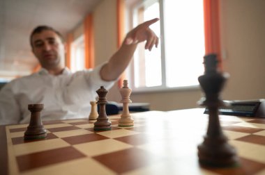 Orta yaşlı beyaz adam satranç oynuyor.