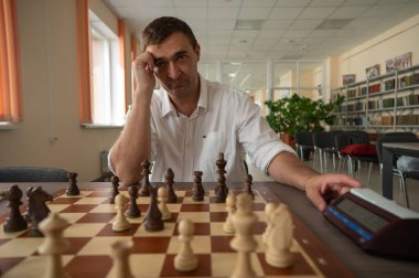 Bir adam satranç saatini değiştirir.