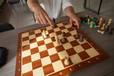 Orta yaşlı beyaz bir adamın satranç oynaması yakındır.