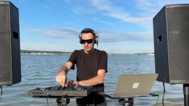 Beyaz adam plajda DJ olarak çalışıyor.