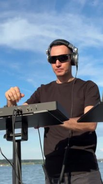 Beyaz adam plajda DJ olarak çalışıyor.