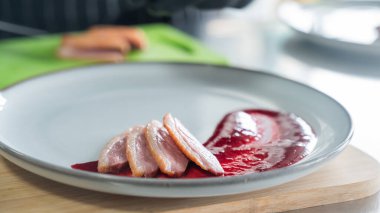 Şef ördeği kızılcık sosuna koyar.