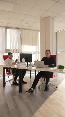 Bir ofiste çalışan iki beyaz adam.