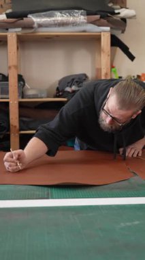 Beyaz sakallı adam bir atölyede bronzlaştırıcı olarak çalışıyor.