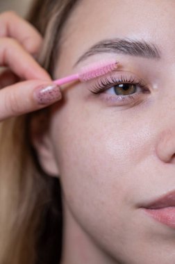 Beyaz kadın kirpiklerini fırçalıyordu.