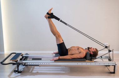 Reformcu üzerinde pilates yapan bir adam.