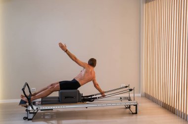 Reformcu üzerinde pilates yapan bir adam.