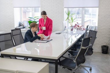 Beyaz kadın astlarına talimat veriyor.