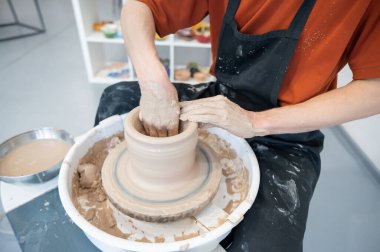Çömlekçi elleriyle çömlekçi çarkında seramik vazo yaparken.