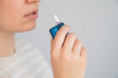 Elektronik sigara içen beyaz bir kadın. Tütün ısıtma sistemi