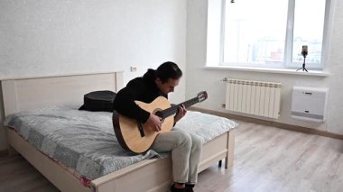 Genç adam akustik gitar çalıyor. Parmak Biçimi