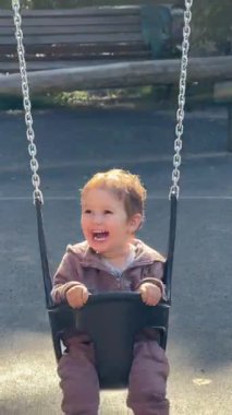 Küçük beyaz çocuk sallanıyor salıncakta