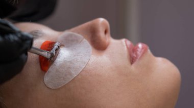 Beyaz kadın kirpik temizleme prosedüründen geçiyor.