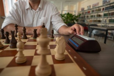 Bir adam satranç saatini değiştirir.