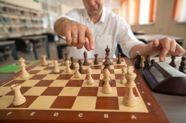 Orta yaşlı beyaz bir adamın satranç oynaması yakındır.