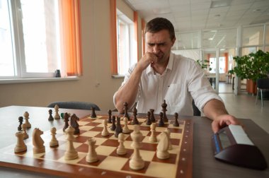 Bir adam satranç saatini değiştirir.