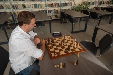 Beyaz adam satranç oyununu kaybettiği için üzgün.