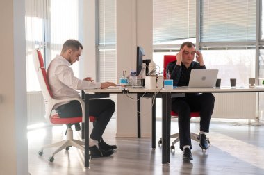 Bir ofiste çalışan iki beyaz adam.