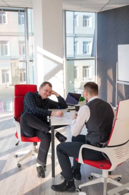 Bir ofiste pazarlık yapan iki beyaz adam.