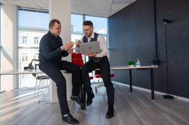 Ofiste iş tartışan iki beyaz adam. İşitme cihazı olan bir iş adamı.