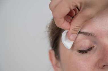 Beyaz kadın kaş boyama prosedürü uyguluyor.