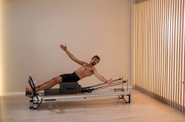 Reformcu üzerinde pilates yapan bir adam.