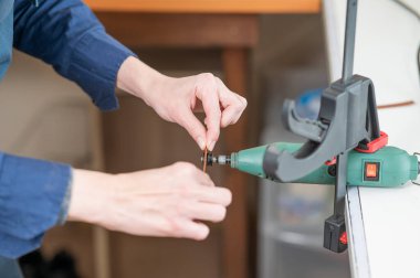 Deri işçisi atölyede kemer için deri şeritlerini öğütüyor.