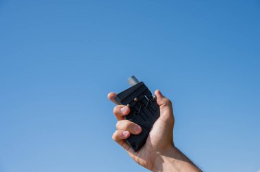 Bir adam acil durum ateşiyle işaret fişeği atıyor. Bir erkeğin elinin yakın çekimi.