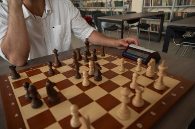 Bir adam satranç saatini değiştirir.