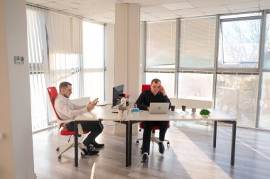 Bir ofiste çalışan iki beyaz adam.