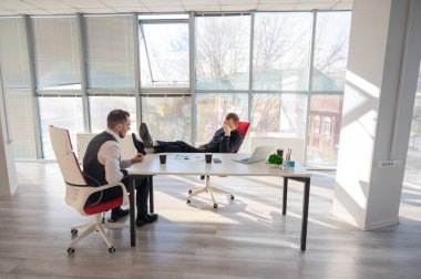 Bir ofiste pazarlık yapan iki beyaz adam.