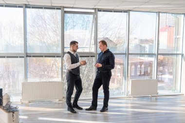 Ofiste konuşan iki beyaz adam.