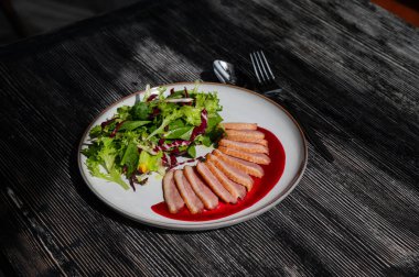 Kızarmış ördek bir tabakta parçalara ayrılmış.