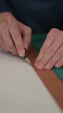 Kadın bir bronzlaştırıcı deri parçaları keser. Deri işçileri atölyesi